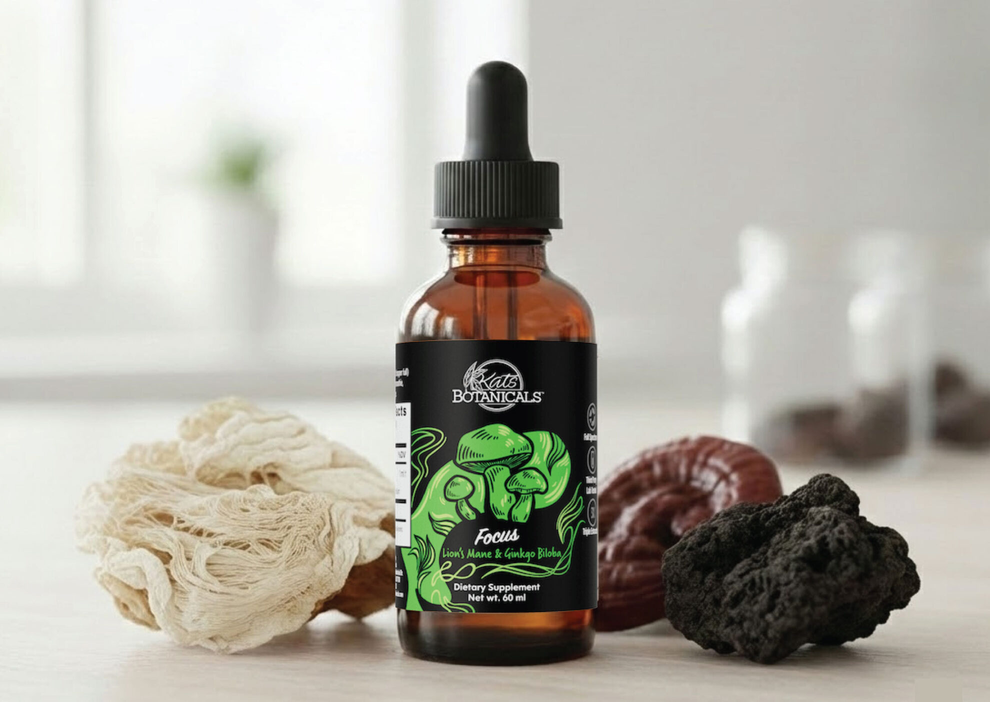 A brown glass dropper bottle labeled Kats Botanicals sits on a light surface, surrounded by different dried mushrooms in white, brown, and black hues. The bottle has a green label with mushroom illustrations.