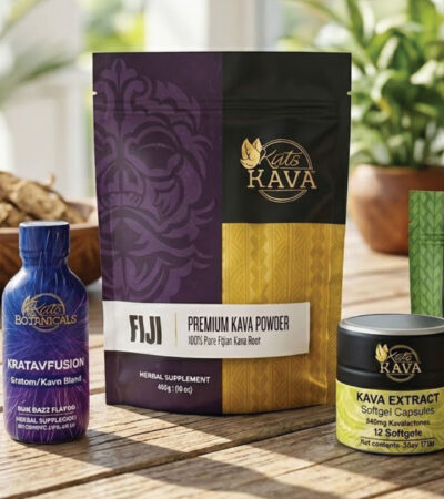 Four Kava products displayed on a wooden table: a blue bottle, a purple and gold bag, a small yellow and black tin, and a green packet, with bowls and plants in the background.